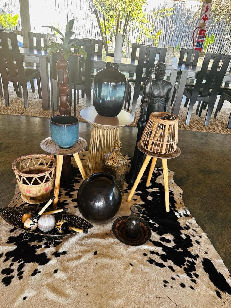 Woven baskets, carved wooden pieces and pottery arranged on a cowhide rug in the lodge lounge