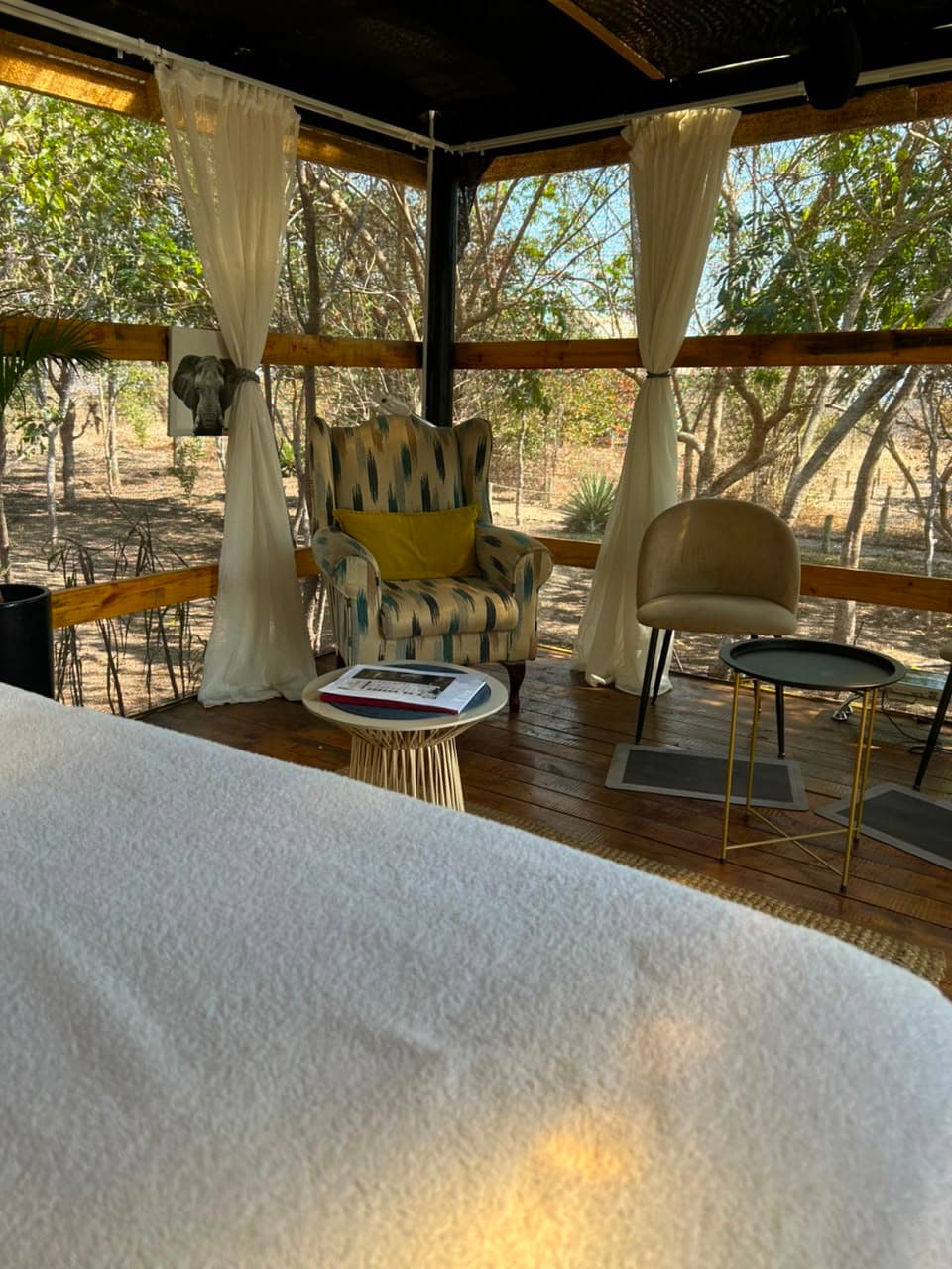 An armchair and side tables on the wooden deck of the spa sala